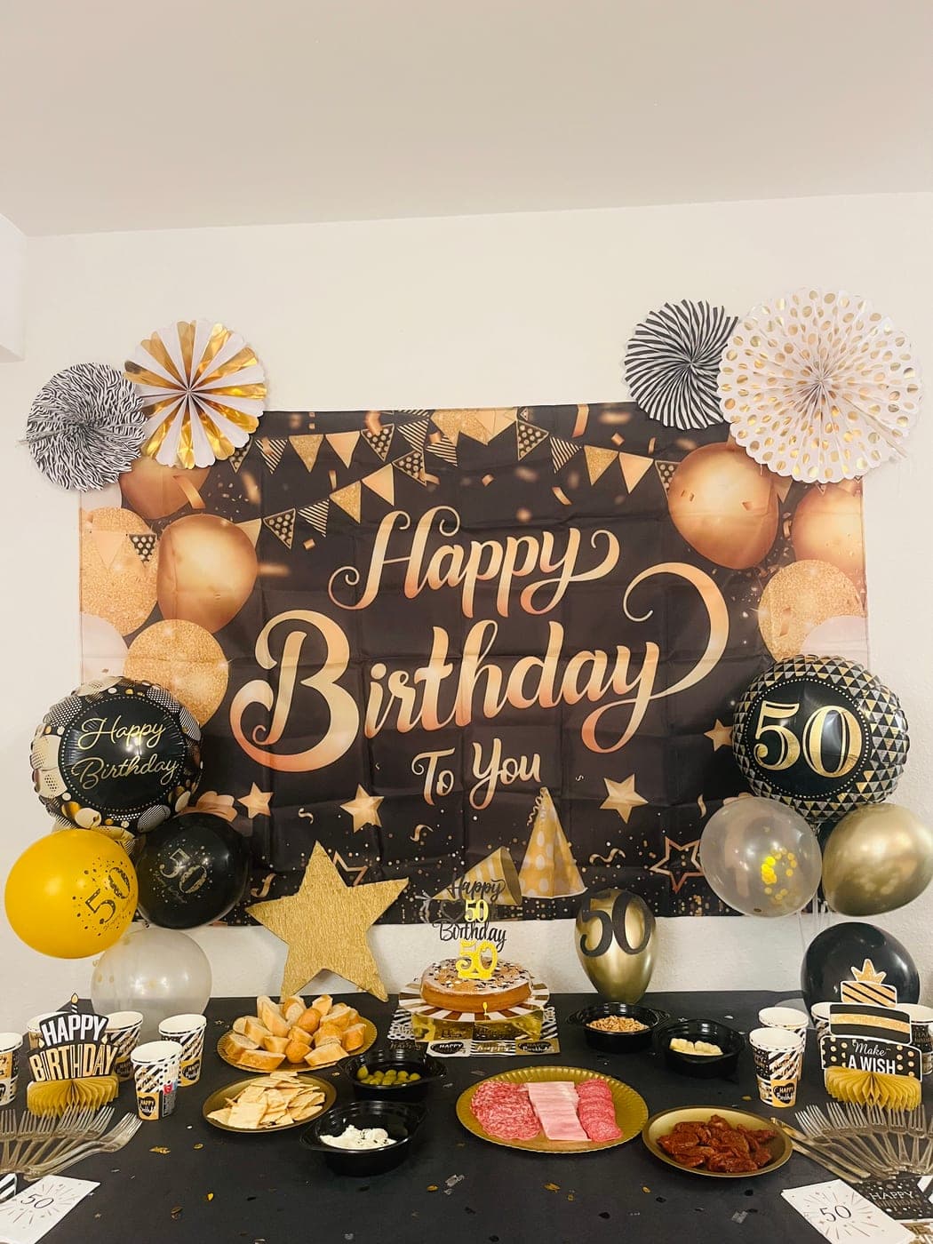 Partytisch mit Ballons, Papierfächern und einem Themen-Hintergrund