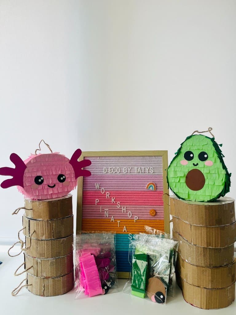 Finished axolotl and avocado mini piñatas with cardboard bases and paper kits